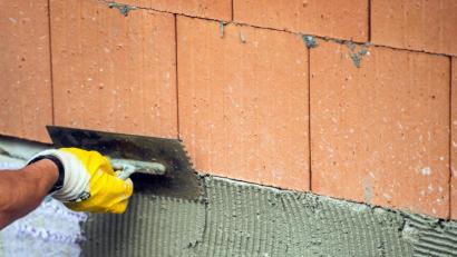 Bild: Lino Mirgeler
Ein Maurer trägt auf einer Baustelle Klebemörtel auf eine Wand auf. Das Handwerk in der Region baut darauf, dass die Gemeinden trotz Corona ihre Bauvorhaben verwirklichen.