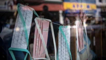 Bild: Sina Schuldt/dpa
Schutzmasken hängen im Schaufenster eines Geschäftes.