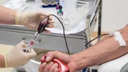 Symbolbild: Christian Charisius/dpa
Eine Mitarbeiterin entnimmt einem Blutspender Blut.