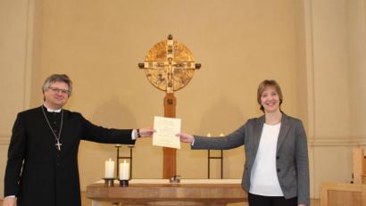 Bild: Veronika Fleps
Dekan Karlhermann Schötz (links) übergibt die Urkunde an Kantorin Kerstin Schatz. Die trägt jetzt den Titel Kirchenmusikdirektorin.