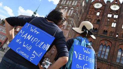 Bild: Stefan Sauer/dpa
Auf einer Demonstration gegen die Maßnahmen zur Eindämmung der Corona-Pandemie tragen zwei Frauen Schilder mit den Aufschriften: "Wer manipuliert die Welt mit Corona?" und "Wer verdient an Corona?"