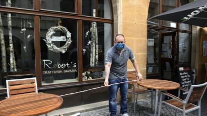 Bild: Petra Hartl
In der Cafébar Trattoria Bavaria am Marktplatz laufen die Vorbereitungen für die ab Montag wieder erlaubte Bewirtung der ersten Gäste auf Hochtouren. Pächter Robert Schaarschmidt könnte von einer geplanten Sonderregelung der Stadt zur Erweiterung der Freischankfläche profitieren – jedoch nur, wenn er nicht 1,5 Meter Sicherheitsabstand zum Gehweg einhalten muss.