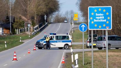 Symbolbild: Sven Hoppe/dpa
Polizisten stehen an einer Kontrollstelle an der Grenze zu Österreich.