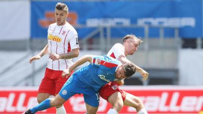 Bild: Alexander Hassenstein/dpa
Fußball mit Zweikämpfen und Körperkontakt: Der Kieler Salih Özcan (vorne) im Infight mit Regensburgs Max Besuschkow.