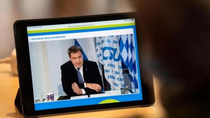 Bild: Lino Mirgeler/dpa
Ein Journalist beobachtet den Livestream vom CSU-Parteitag, bei dem Markus Söder (CSU), CSU-Parteivorsitzender und Ministerpräsident von Bayern spricht.