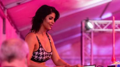 Bild: Armin Weigel/dpa
Nackt-Model Micaela Schäfer steht auf einer Bühne im Strip-Drive-In und legt als DJane auf.