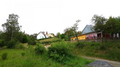 Bild: fjo
Unterhalb der Mehrzweckhalle (rechts) soll der Marktflecken durch ein neues Baugebiet wachsen. Weitere Parkplätze für den Rathausanbau sind im Wege der Umplanungen angedacht.