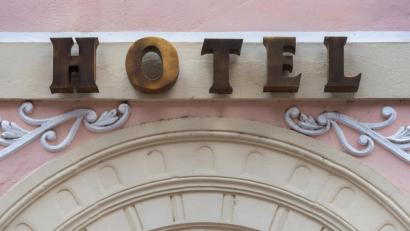 Symbolbild: Robert Michael/dpa
Der Schriftzug „Hotel“ steht über dem Eingang eines Hotels. Foto: Robert Michael/dpa-Zentralbild/dpa/Symbolbild