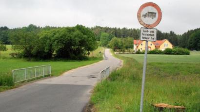 Bild: sche
Der Freudenberger Gemeinderat gibt grünes Licht für die Sanierung der Straße, die die Ortschaft Greßmühle mit der Stadt Amberg (Bild hinter dem Anwesen rechts) verbindet. Dafür ist auch der Neubau einer Brücke (im Vordergrund) erforderlich.