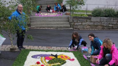 Bild: kro
Vor der Schwarzenbacher Pfarrkirche legten die Familien Mark und Friedl an Fronleichnam farbenfrohe Blumenteppiche.