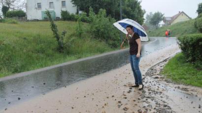 Bild: pi
Bürgermeisterin Marina Hirnet macht sich an der Verbindungsstraße zwischen Georgenberg und Neukirchen in Höhe der Abzweigung Alte Königsstraße ein Bild von den Unwetterschäden an den Banketten.