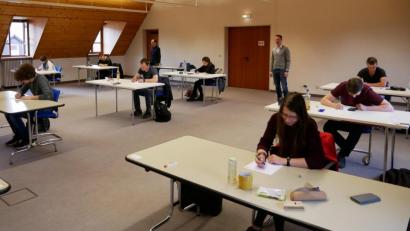 Bild: flm
Die Anwärter der 2. Qualifikationsebene bei der Prüfung im Sparkassensaal. Im Hintergrund ihre Betreuer Henri Buschmann (rechts) und Friedrich Ederer (links).
