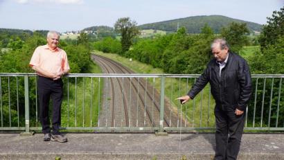 Bild: bkr
Um 80 Zentimeter muss die Brücke in Lenau für die Elektrifizierung angehoben werden. Zweiter Bürgermeister Albert Sollfrank (links) zeigt es dem Rathauschef Günter Kopp mit dem Maßband an.