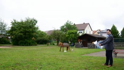 Bild: bey
Im Bereich der linken Baum- und Buschgruppe soll der Neubau errichtet werden. Bürgermeister Sebastian Hartl macht sich vor der Marktgemeinderatssitzung nochmal ein genaues Bild von der Örtlichkeit. Die Terrasse (im Hintergrund mit der Sitzbank) soll überdacht werden, außerdem wird in diesem Bereich der Verbindungsgang zum bestehenden Kinderhaus errichtet.
