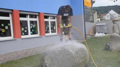 Bild: fz
Zwei Stunden Staub und Muskelkraft, dann hatte Bürgermeister Markus Ziegler die Leitung durch den 8400 Zentner schweren Stein für den Dorfbrunnen gebohrt.