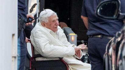 Archivbild: Daniel Karmann
Der emeritierte Papst Benedikt XVI wird in Regensburg mit einem Rollstuhl in einen Bus geschoben.