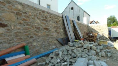 Bild: Portner
Die Freifläche "Hauptstraße 2/Altes Schulhaus" mit Steinmauer unterhalb der Pfarrkirche nimmt Formen an.