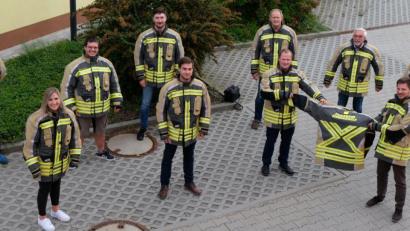 Bild: mab
Zusammen mit den Verantwortlichen der vier Ortsfeuerwehren präsentieren die zuständige Mitarbeiterin im Rathaus für Feuerwehraufgaben, Teresa Scholz, sowie Bürgermeister Peter Neumeier (vorne rechts) mit seinem Vorgänger Manfred Rodde (dahinter) die neuen Schutzanzüge.