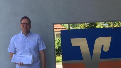 Bild: gz
Dritter Bürgermeister Bernd Reil präsentiert die Unterschriften, die er den Vertretern der Raiffeisenbank übergibt.