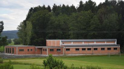 Bild: fz
Blick vom Gleitsbachtal auf die Rückseite des Feuerwehrhauses. Links davon (grünes Band) verläuft der Gleitsbach, der renaturiert werden soll.