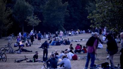 Bild: Christoph Soeder/dpa
Menschen sitzen nachts im Volkspark Hasenheide auf einer Wiese.