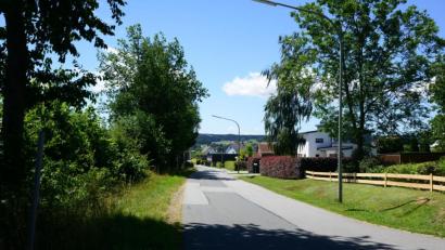 Bild: bey
Die Straße "Sandweg" ist nur einseitig bebaut (rechts). Auf der linken Seite grenzen landwirtschaftlich genutzte Flächen an. Ein Problem laut Verwaltung, weil sich hier kein "Zonenbewusstsein" entwickelt.