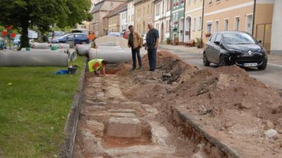 Bild: ow
Bei Baggerarbeiten des Kanalprojekts wird westlich des Rathauses der Kulmstadt ein Fundament entdeckt. Vermutlich stammt dieses vom Alten Rathaus, das wahrscheinlich bereits schon vor 1611 erbaut und das 1945 bei einem Luftangriff der Amerikaner zerstört wurde. Im Graben reinigt eine Archäologin vom Büro Scherbaum die Fundamentsteine. Am Grabenrand erläutert der Hobbyheimatforscher Georg Miedel (rechts) Bürgermeister Wolfgang Haberberger (links) seine Theorie zum Alten Rathaus.