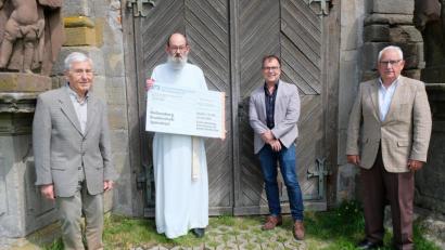 Bild: do
Vor dem Portal der Barbaraberg-Kapelle überreichen Stiftungsvorsitzender Georg Girisch (von rechts) sowie die Vorstandsmitglieder Michael Menner und Ludwig König (von links) an Pater Benedikt Schuster den symbolischen Spendenscheck.
