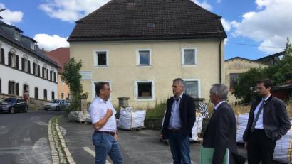 Bild: cro
Vor dem „Schlössl“ mit dem früheren Gutshaus im Hintergrund diskutiert Bürgermeister Thomas Meiler mit seinen Gästen die Möglichkeiten der Dorferneuerung in Altenhammer.