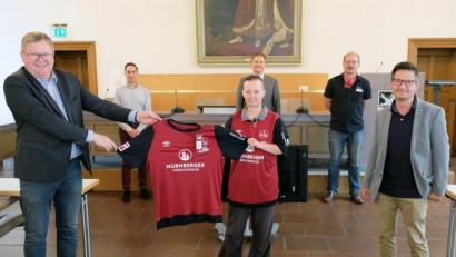Bild: Susanne Schwab/exb
Oberbürgermeister Michael Cerny (links) übergibt im Beisein von Stefan Bruckner, Bernhard Mitko und Hans-Jürgen Haas (hintere Reihe, von links) die beiden Ehrentrikots des 1. FC Nürnberg an Carmen Birner vom Busunternehmen Reichert sowie Rolf Wilschütz von der Firma Linzer (rechts).