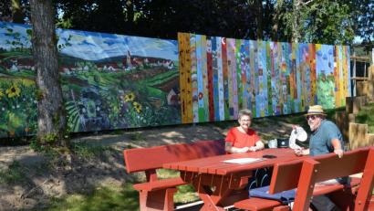 Bild: Anne Wiesnet
Ein 34 Meter langes Kunstwerk rahmt den Sassenreuther Spielplatz ein. Ein Teil stammt von Künstler Dieter Windisch (rechts). Die anderen Holzbretter haben mehrere Dorfbewohner bemalt. Die Idee dazu hatte Silvia Schecklmann (links).