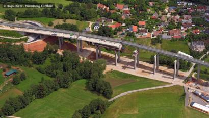 Bild: Hajo Dietz/Nürnberg Luftbild 
Mehr als die Hälfte der alten Brücke ist bereits abgerissen. Auf dem Bild lassen sich schon die neuen Pfeiler erkennen.