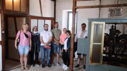 Bild: cog
Stadtpfarrer Roland Kurz (rechts) zeigt den internationalen Gästen das Uhrwerk im Turm der Christuskirche.