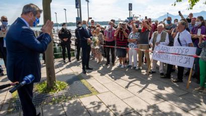 Bild: Peter Kneffel/dpa
Ministerpräsident Markus Söder (CSU) wehrt die Fankundgebung mit dem Plakat „Markus Söder – Kanzlerkandidat? Ja“ dezent ab