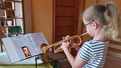 Bild: Portner
Musikunterricht per Whatsapp-Videoanruf: Mila Juraske (9) spielt das Stück auf der Trompete vor und Ausbilder Stefan Karl hört am Handy mit.