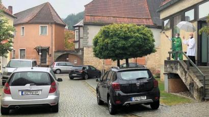 Bild: bjo
Pfarrer Werner Sulzer (rechts) segnet die vorbeifahrenden Autos mit Weihwasser.