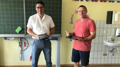 Bild: bey
Bürgermeister Reinhard Sollfrank übergibt symbolisch die Leih-Tablets, die für Schüler gedacht sind, an Rektor Armin Aichinger.