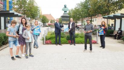 Bild: Philipp Reich, Jugendmedienzentrum T1/exb
Plakate sollen auf die „Digitale Schnitzeljagd“ in Tirschenreuth verweisen. Im Bild die Präsentation mit Vertretern des Jugendmedienzentrums T1, Kreisjugendringvorsitzenden Jürgen Preisinger und Bürgermeister Franz Stahl (Dritter und Vierter von rechts) sowie ersten Testern des „Actionbounds“.
