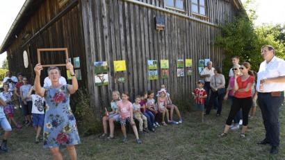 Bild: Petra Hartl
Das mehrtägige Ferienprogramm „Malen im Freien“ mit Dorothe Pfeiffer (stehend, vorne) von der Werkstatt für Kinder kam bestens an: Bei der Abschlusspräsentation auf dem Gelände der Umweltwerkstatt Amberg (UWA) zeigten die Kinder ihren Eltern die selbstgemalten Motive (im Hintergrund an der Scheune).