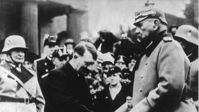 Archivbild: -/UPI/dpa
Das auf den 25. Februar 1934 datierte Foto zeigt die Begrüßung Paul von Hindenburgs (rechts) durch den Reichskanzler Adolf Hitler am «Heldengedenktag» vor der Neuen Wache, Unter den Linden. Links im Bild Hermann Göring.