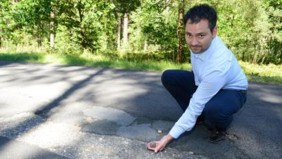 Bild: bey
Die Asphaltdeckschicht auf der Gemeindeverbindungsstraße Oberwildenau-Kohlberg ist so marode, dass Bürgermeister Sebastian Hartl mit bloßen Händen Teile des Belags entfernen kann.