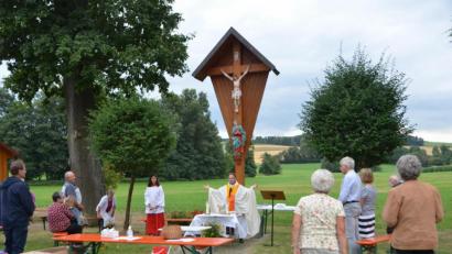Bild: dob
Vor dem Dorfkreuz versammeln sich die Gläubigen mit Dekan Alexander Hösl zum Gottesdienst. Die gesellschaftliche Feier dagegen muss ausfallen. Die Teilnehmer hatten auf dem Dorfplatz viel Raum um den geforderten Abstand einzuhalten.