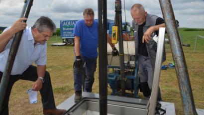 Bild: dob
Bürgermeister Andreas Wutzlhofer (links) überzeugt sich persönlich von den Regenerierungsarbeiten am Tiefbrunnen I bei Neumühle, bei dem Mitarbeiter der Firma Aquaplus Brunnensanierung H. Munding GmbH & Co.KG aus Kronach gerade damit beschäftigt sind, den Brunnenkopf und die Steigleitung zu demontieren.
