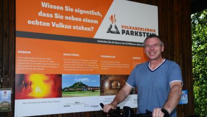 Bild: bey
In dieser und in der nächsten Woche hat Bürgermeister Reinhard Sollfrank offiziell Urlaub. Deshalb radelt er im Freizeitlook durch den Markt Parkstein – mit dem Laptop im Korb natürlich, weil sich an die Rundtour doch noch ein Gespräch wegen eines Grundstückskaufes anschließt. Auf dem Bild im Hintergrund beobachtet Sohn Michael den "glühenden" Vulkan.