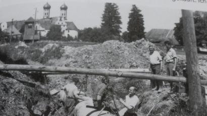 Bild: Schieder/bk
800 Meter Rohrleitung mit 80 Zentimeter Durchmesser mussten zum Stauweiher unter einer Straße und Bahngleis verlegt werden. "Drei Monate lagen wir in den Rohren. An der Schweißstelle war es warm, aber im Rücken saukalt", erinnert sich Laienbruder Georg Schieder (vorne, rechts), der Schlosser gelernt hat. Im Hintergrund zu sehen das Kloster Benediktbeuern.