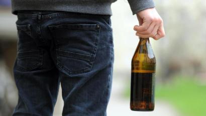 Symbolbild: Tobias Hase/dpa
Ein Jugendlicher hält eine geöffnete Bierflasche in der Hand.