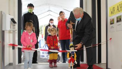Bild: Sven Lehner/exb
Zweiter Bürgermeister Peter Gold durchschneidet zusammen mit seiner Marionette Pinocchio und den ersten Weltentdeckerinnen das symbolische Band zur Eröffnung des BRK-Kinderhauses.