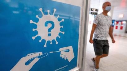 Bild: Lino Mirgeler/dpa
Ein Hinweis auf die Corona-Teststation am Flughafen München.