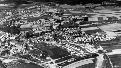 Repro: T. Sporrer, Archiv A. Mayer.
„Vor den Toren der Stadt“: Die Luftaufnahme um 1965 zeigt die auch damals noch exponierte Lage des Siedlerwegs (unten rechts), weit vor den östlichen Toren der Stadt. Erst im Laufe der Jahrzehnte wuchs die Siedlung der Heimatvertriebenen ins Stadtbild ein.