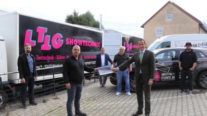 Bild: vlu
Tobias Grünes (zweiter von links) übergibt Politiker Albert Rupprecht eine Mappe mit den wichtigsten Infos, wo der Schuh in der Eventbranche drückt.